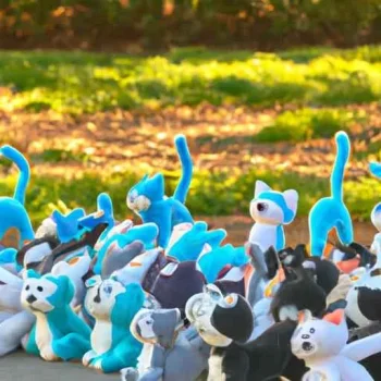 A stampede of happy felt plushie cats in a park during the day, captured in a long shot. (2).jpg